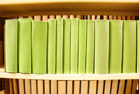 Bookshelf with stack of green coloured books