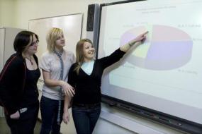Three girls talking about pie chart