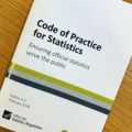 A copy of the code of practice for statistics on a table top.