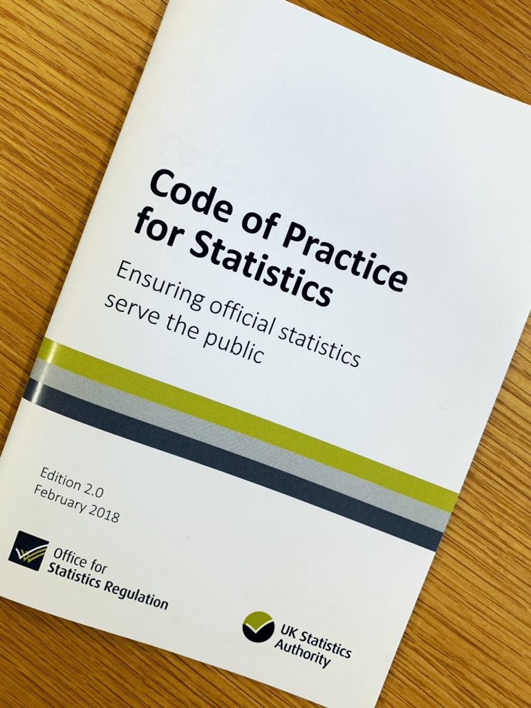 A copy of the code of practice for statistics on a table top.
